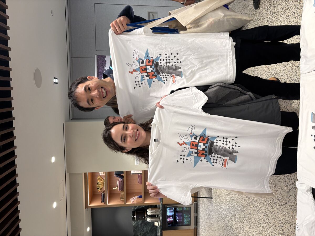 Two HAC NYC attendees holding up the custom King-Kong-on-Statue-of-Liberty HAC NYC t-shirt design