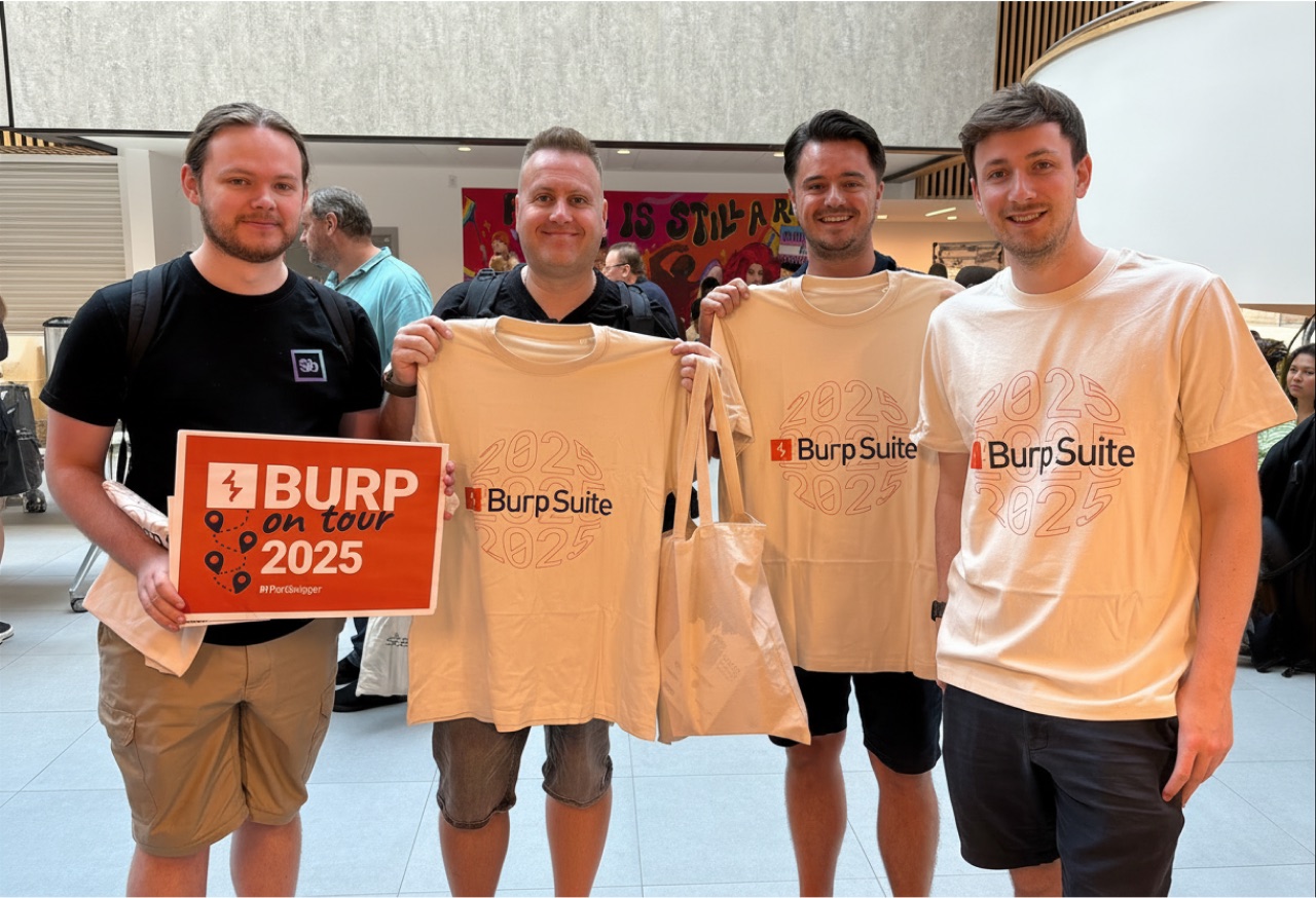 Four attendees holding Burp Suite "Burp on tour 2025" t-shirts and merch