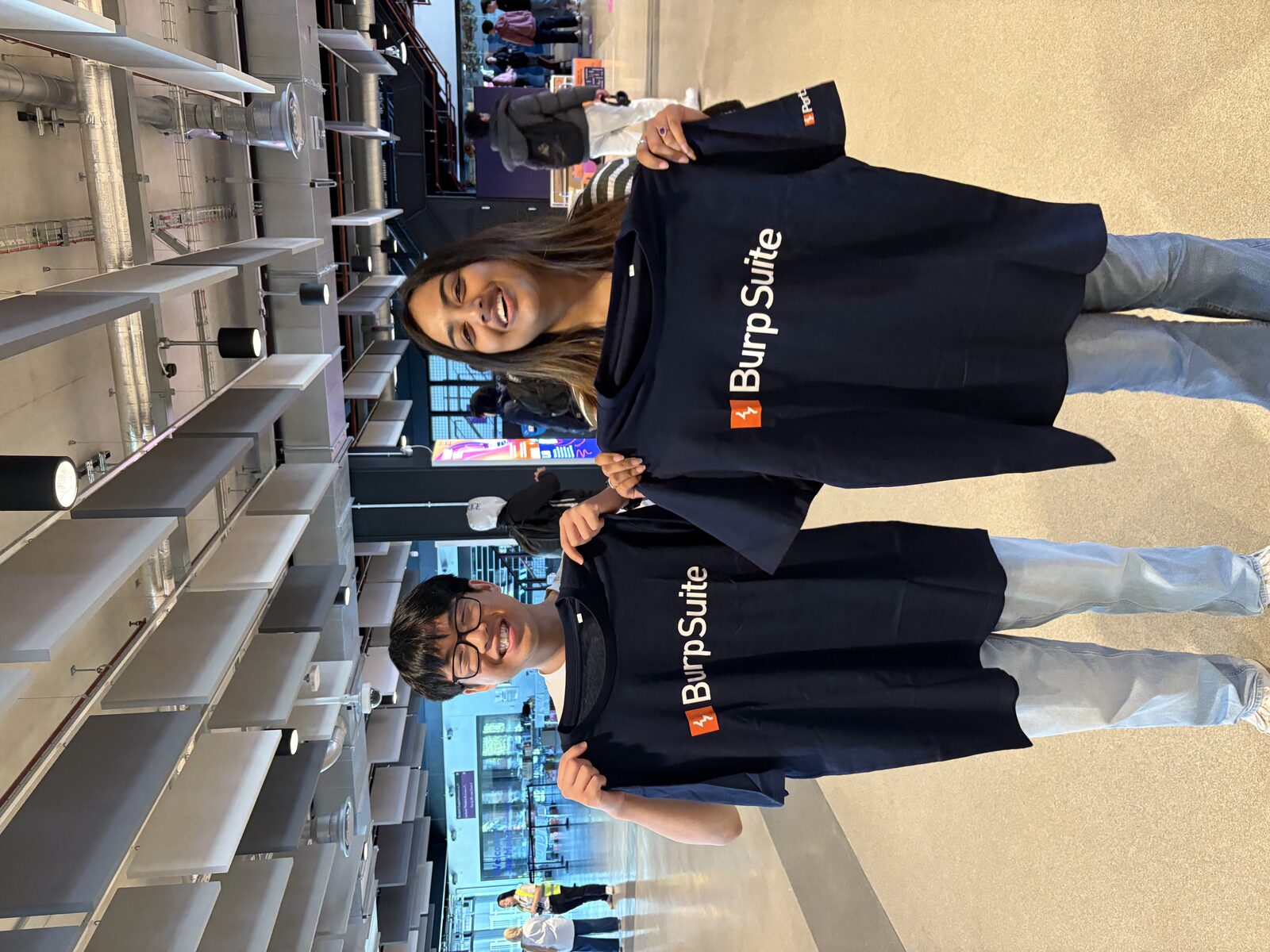 Students holding Burp Suite t-shirts