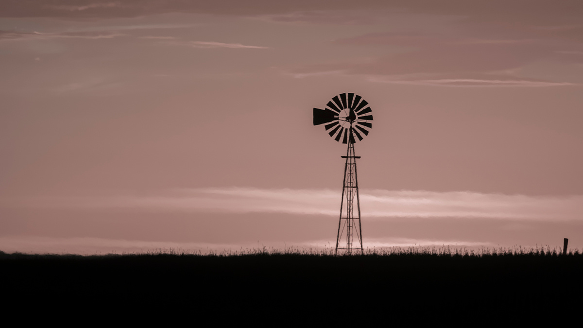 Windmill in countryside at sunset